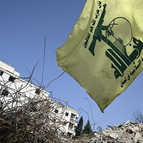 A flag of the Lebanese Shiite movement Hezbollah flutters above the rubble of a building that was hit in January by an Israeli strike in the southern Lebanese village of Qannarit, on Feb. 16, 2026.
