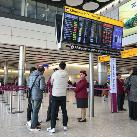 Staff from Qatar Airways help assist people with questions at their empty check-in area at London Heathrow Airport in west London on March 1, 2026, as flights are severely disrupted following the US and Israel's strikes on Iran. 