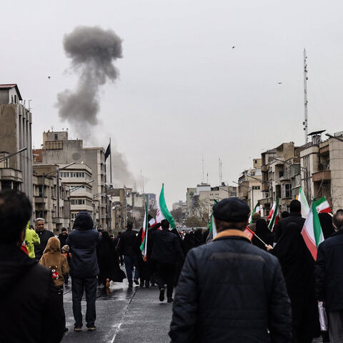 Black smoke rises following an airstrike, as Iranians take part in the Al-Quds (Jerusalem) Day rally, a commemoration in support of the Palestinian people on the last Friday of the Islamic holy month of Ramadan, in Tehran on March 13, 2026. 