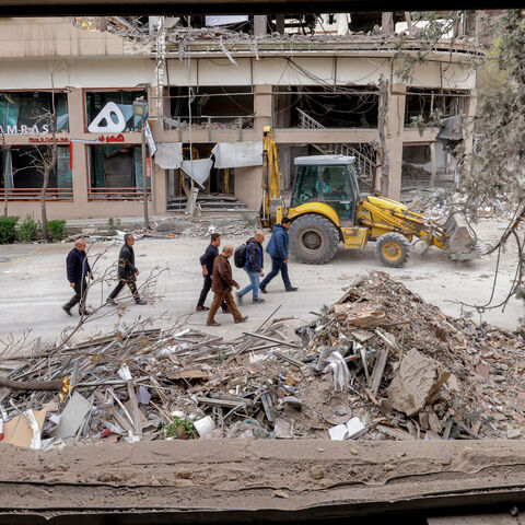 People inspect destruction at a business building that housed the offices of the Doha-headquartered news network Al Araby TV following a missile strike earlier in the day, Tehran, Iran, March 29, 2026.