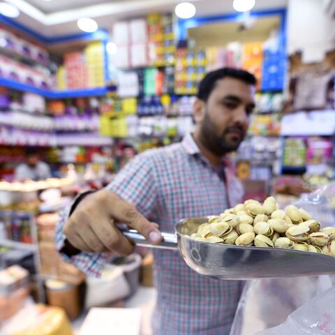 An Iranian grocer sells pistachios imported from Iran at a Persian products shop in the Gulf emirate of Dubai on July 10, 2019. (Photo by Karim SAHIB / AFP) (Photo credit should read KARIM SAHIB/AFP via Getty Images)