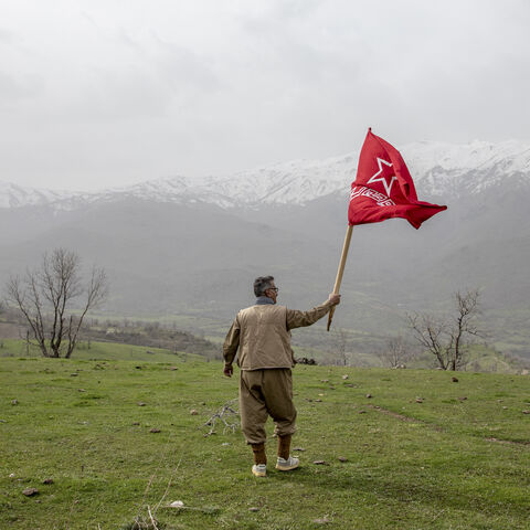 A armed Kurdish Peshmerga of the Komala party waves the Komala flag in a ceremony held in memory of Komala Martyrs' Day in Sidakan, Kurdistan Region of Iraq, on March 17, 2021.