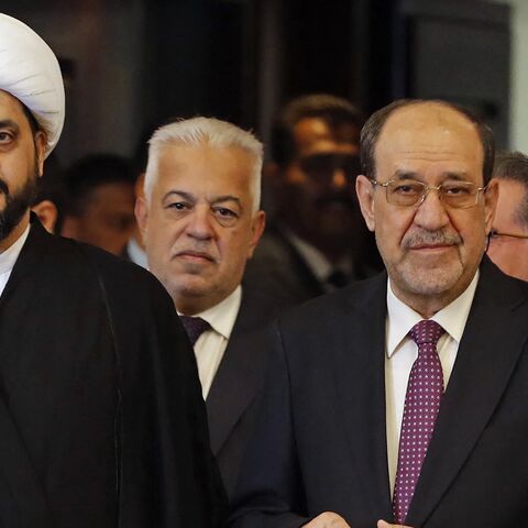Qais al-Khazali (L), head of the Asaib Ahl al-Haq group, stands along with former Iraqi Prime Minister Nouri al-Maliki after casting their ballots at a polling station in Baghdad on Nov. 11, 2025.