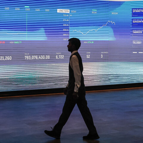 A man walks past a screen displaying stock indices at the Dubai Financial Market stock exchange in Dubai, March 4, 2026.