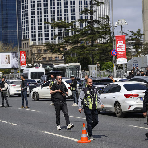 Police officials stand among traffic as they patrol near the Israeli Consulate following a shootout between gunmen and police, Istanbul, Turkey, April 7, 2026.