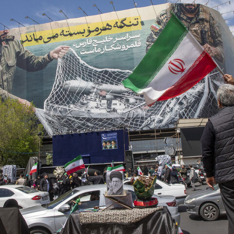 Iranians hold national flags as they gather in Tehran's Revolution Square after the United States and Iran agreed to a two-week ceasefire, on April 8, 2026 in Tehran, Iran. 