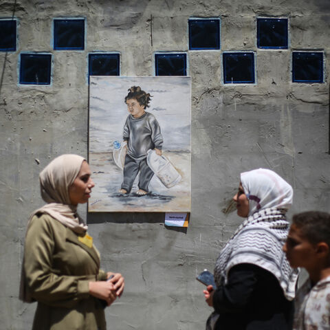 Displaced Palestinian people look at paintings at an open-air art exhibition at the Bureij camp for Palestinian refugees in the central Gaza Strip on April 28, 2026. The majority of Gaza's 2.4 million people have been displaced, often multiple times, by the war that began with Hamas's attack on southern Israel on October 7, 2023. With displaced families living in tented camps, with serious concerns raised about their living conditions. (Photo by Eyad Baba / AFP via Getty Images) / -- IMAGE RESTRICTED TO EDI