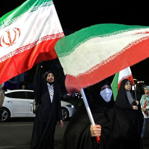 Women hold Iran's national flags during an anti-US and Israel protest in Tehran 