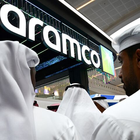 Guests stand at the Aramco booth during the Abu Dhabi International Petroleum Exhibition & Conference in Abu Dhabi on Nov. 3, 2025. 