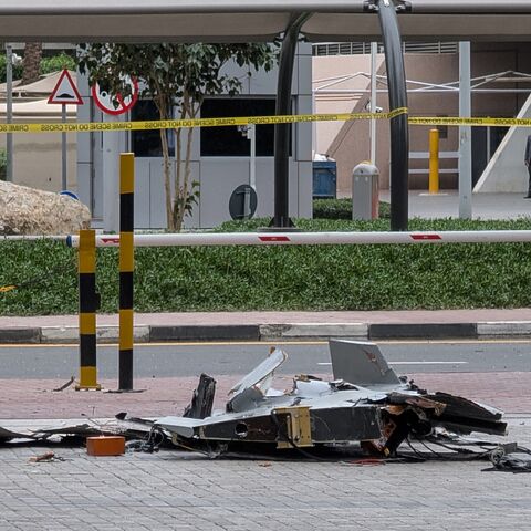 A policeman inspects the wreckage of a drone in downtown Dubai on March 12, 2026. 