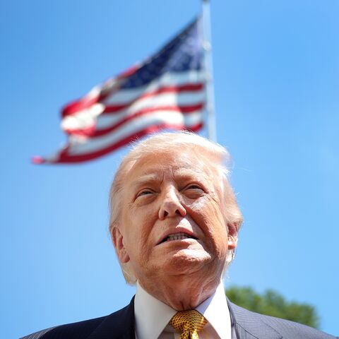 President Donald Trump speaks in front of the American flag to the press as he departs the White House on May 12, 2026, in Washington, DC. 