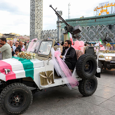 A bride and group couple rides in a military jeep arriving for a public mass wedding ceremony at Imam Hossein Square in Tehran on May 18, 2026. Iran said on May 18 that it had responded to a new US proposal aimed at ending the war, adding that diplomatic exchanges continue despite Iranian media reports describing Washington's demands as excessive. Washington and Tehran have been swapping proposals in an effort to end the conflict which the US and Israel launched on February 28, but they have held only a sin
