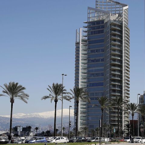 A picture shows the four seasons hotel in Beirut with the snow covered mountain of Sannine in the background on March 8, 2019. 
