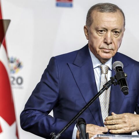 Turkey's President Recep Tayyip Erdogan buttons up his jacket during a press conference after the conclusion of the G20 Leaders' Summit at the Nasrec Expo Centre in Johannesburg on November 23, 2025. 