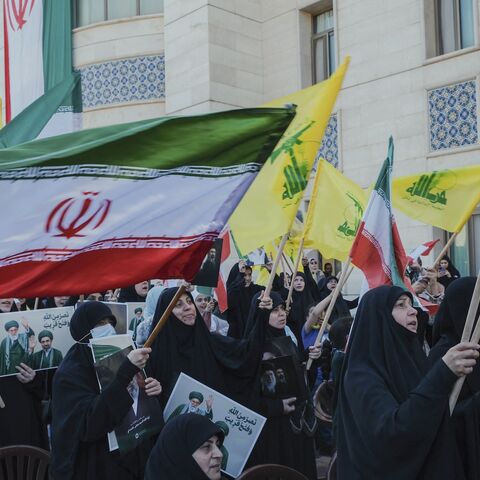 Veiled women in black Chadors wave Iran and Hezbollah flags during commemoration at the Iranian embassy in Beirut, Lebanon, on April 22, 2026.