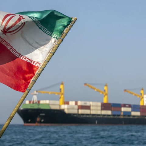 An Iranian flag flutters in the wind as ships remain anchored on May 16, 2026 in the Strait of Hormuz near Larak Island, Iran.  
