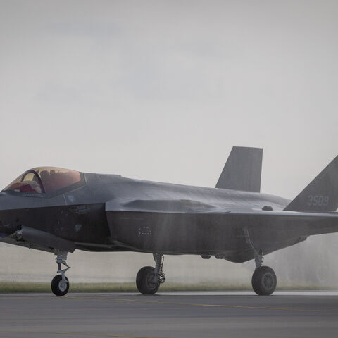 One of the first three US-made F-35 aircraft in Polish Air Force colors taxis along the runway at the 32nd Tactical Air Base in Lask, central Poland, while fire-fighting vehicles perform a water salute on May 22, 2026. 
