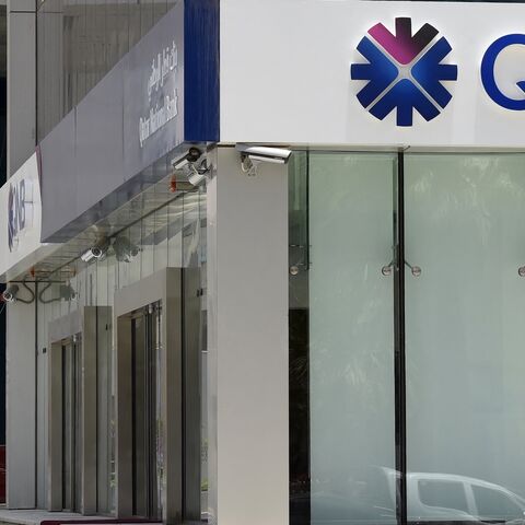 A picture taken on June 5, 2017, shows a man walking past the Qatar National Bank branch in the Saudi capital Riyadh. 