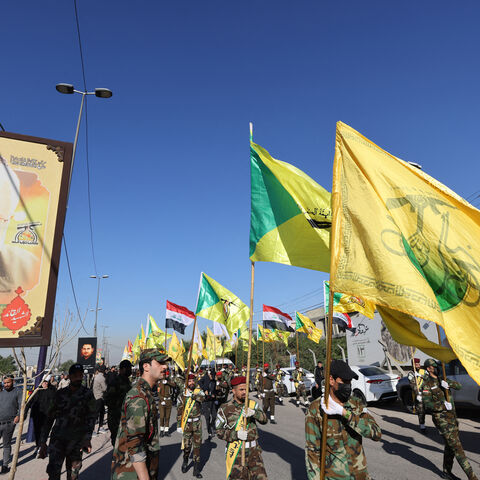 Fighters lift flags of Iraq and paramilitary groups, including al-Nujaba and Kataib Hezbollah, during a funeral in Baghdad for five militants killed a day earlier in a US strike in northern Iraq, on Dec. 4, 2023. 