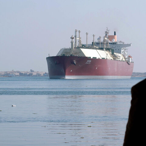 An Egyptian man looks at the Qatari Liquefied Natural Gas (LNG) carrier "Duhail" as its passes through the Suez Canal near the Egyptian port city of Ismailia on April 1, 2008. The vessel has a capacity of 210,100 cu.m making it one of the largest LNG carriers constructed to date. AFP PHOTO/STR (Photo credit should read -/AFP via Getty Images)