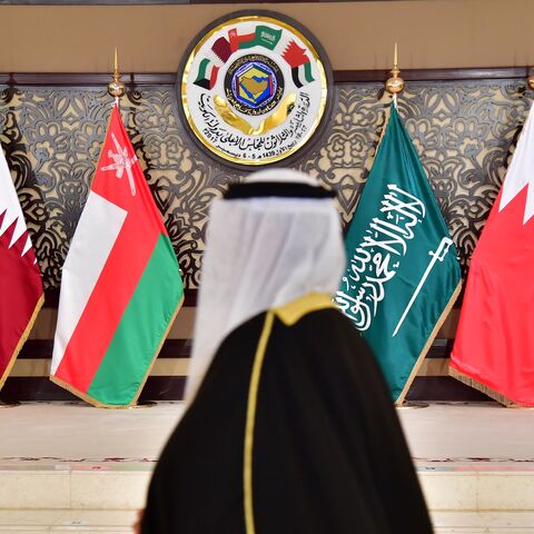 A man walks past the flags of the countries attending the Gulf Cooperation Council summit at Bayan palace in Kuwait City on Dec. 5, 2017.