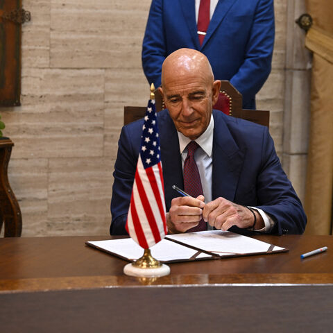 Syrian Foreign Minister Asaad al-Shaibani (C) watches as US special envoy for Syria Tom Barrack prepares to sign an agreement in Damascus on September 16, 2025. Shaibani announced on September 16 a plan backed by Jordan and the United States to restore calm to Druze-majority Sweida province, which witnessed deadly violence in July. (Photo by LOUAI BESHARA / AFP) (Photo by LOUAI BESHARA/AFP via Getty Images)