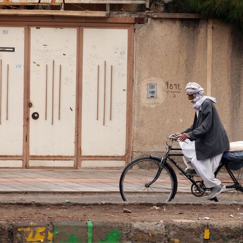 A Baluch Iranian man rides a bicycle