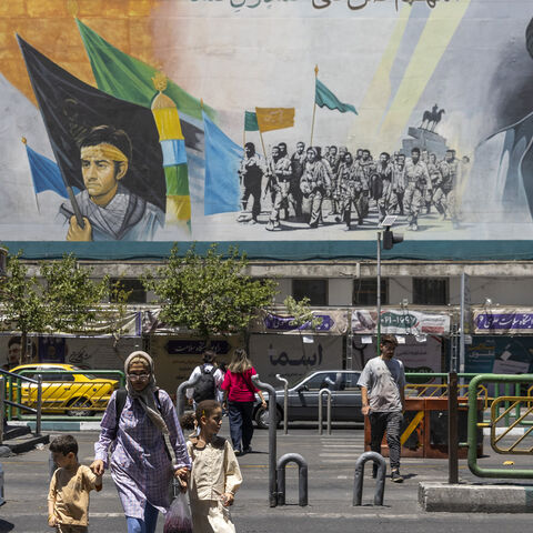Pedestrians walk past a billboard depicting Iran's late Supreme Leaders Ayatollah Ruhollah Khomeini and Ayatollah Ali Khamenei, Tehran, Iran, June 15, 2026.