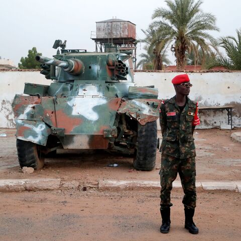Sudanese army soldier stands in front of a tank