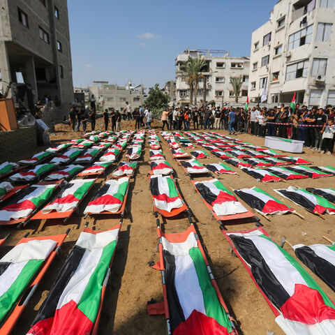 People attend a mass funeral for members of the Abu Sharia and Al-Hasayna families, whose remains were recently recovered from the rubble of their homes after an attack earlier in the war, on Aug. 4, 2026 in the Sabra neighborhood of Gaza City, Gaza. 
