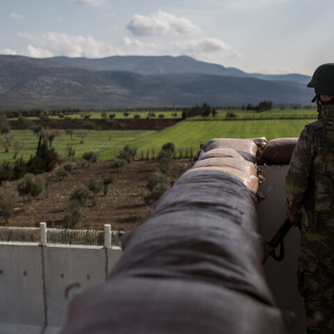 A Turkish soldier from the 1st Border Regiment Command looks out over the border wall to Syria during alert drills at a military outpost on the Turkey/Syria border on March 2, 2017 in Kilis, Turkey. 
