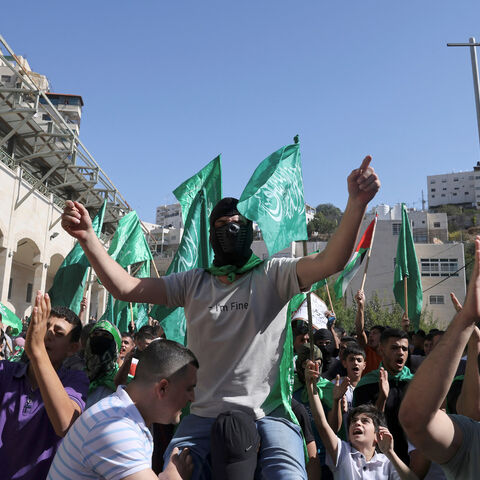 Palestinians hold up the green Hamas flag during a protest by supporters of both the Fatah and Hamas movements, as they rally in support of the Palestinian people following Friday noon prayers in Hebron, occupied West Bank, Nov. 3, 2023.