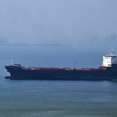 A tugboat guides a ship at the Khor Fakkan Container Terminal, the only natural deep-sea port in the region and one of the major container ports in Sharjah Emirate, along the Gulf of Oman on July 14, 2026.
