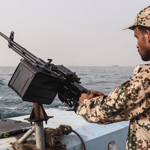 A sailor from the navy of Yemen's Aden-based internationally recognized government stands at a machine-gun position aboard a vessel patrolling a shipping lane off Hanish Island in the Red Sea on July 27, 2026.