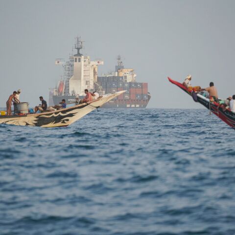 boats and a container ship near the Strait of Bab al-Mandeb