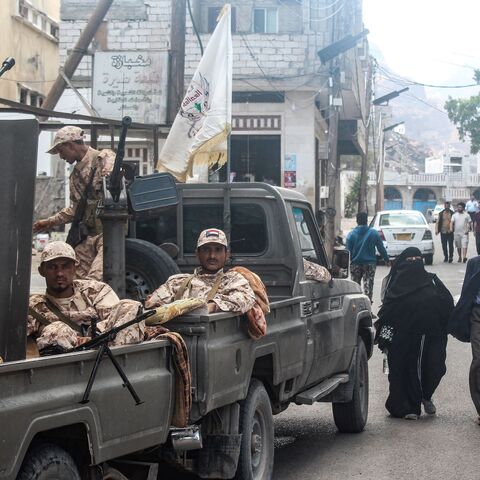 Members of the Southern Giants Brigade sit in the back of military vehicles