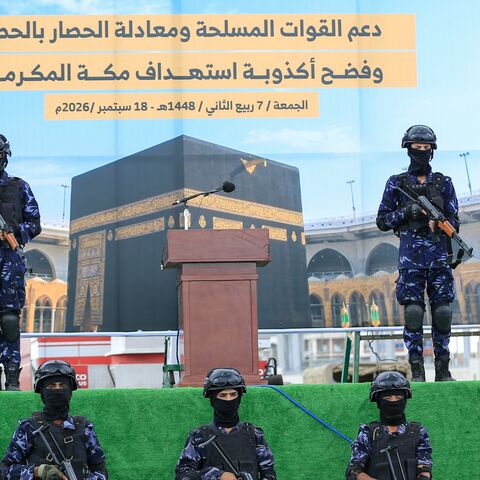 Security forces stand guard in front of a banner showing the Kaaba during a protest by supporters of the Houthi authorities against the Saudi intervention in Yemen and against Saudi Arabia's recent accusation that the Houthis fired at the holy city of Mecca, in Sanaa on Sept. 18, 2026. 