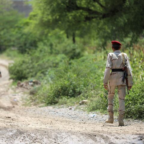 Saudi-backed Yemeni government forces walk along a dirt road