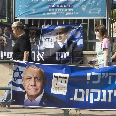 Israelis pass by campaign posters featuring Israeli Prime Minister, Benjamin Netanyahu, and Yashar Party leader, Gadi Eisenkot, near a polling station during Israel's general elections on October 27, 2026 in Hadera, Israel.