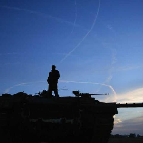 An Israeli soldier atop a tank looks at air force fighter jets circling overhead an Israeli Defence Forces (IDF) staging area in the northern Gaza border November 21, 2012. Israeli air strikes shook the Gaza Strip and Palestinian rockets struck across the border as U.S. Secretary of State Hillary Clinton held talks in Jerusalem in the early hours of Wednesday, seeking a truce that can hold back Israel's ground troops.  REUTERS/Yannis Behrakis (ISRAEL - Tags: CONFLICT MILITARY POLITICS TRANSPORT TPX IMAGES O