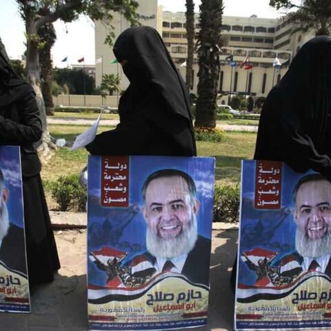 Supporters of Hazem Salah Abu Ismail, a Salafist leader and presidential candidate, carry his posters before his arrival to present recommendation documents to the Higher Presidential Elections Commission (HPEC) headquarters in Cairo March 30, 2012. The presidential election will be held on May 23 and 24.     REUTERS/Asmaa Waguih (EGYPT - Tags: POLITICS ELECTIONS) - RTR304AE