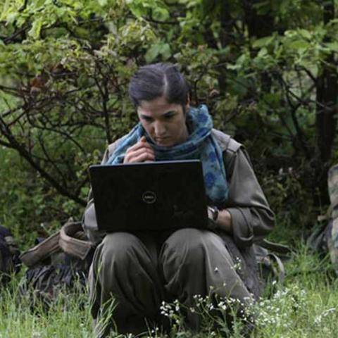 A member of Kurdistan Workers Party (PKK) works on her laptop in northern Iraq May 14, 2013. The first group of Kurdish militants to withdraw from Turkey under a peace process entered northern Iraq on Tuesday, and were greeted by comrades from the Kurdistan Workers Party (PKK), in a symbolic step towards ending a three-decades-old insurgency. The 13 men and women, carrying guns and with rucksacks on their backs, arrived in the area of Heror, near Metina mountain on the Turkish-Iraqi border, a Reuters witnes