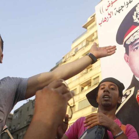 Protesters cheer with drums near a poster of army chief Abdel-Fattah El-Sisi as they gather for a mass protest to support the army in Tahrir square in Cairo July 26, 2013. Ousted Egyptian president Mohamed Mursi is under investigation for an array of charges including murder, the state news agency said on Friday, stoking tensions as opposing political camps took to the streets. Confirming the potential for bloodshed, two men were killed in confrontations in Alexandria and a further 19 were hurt, Mena news a