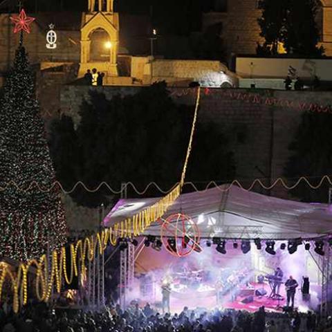Musicians perform on stage in Manger Square, outside the Church of the Nativity, the site revered as the birthplace of Jesus, in the West Bank town of Bethlehem December 1, 2013. REUTERS/Ammar Awad (WEST BANK - Tags: RELIGION) - RTX1605A