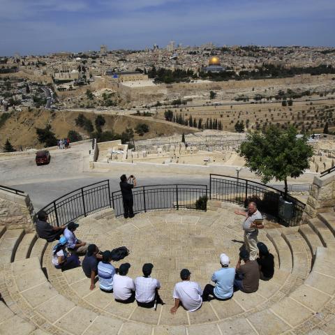 Tourists sit at a lookout point on the Mount of Olives, overlooking Jerusalem's Old City May 25, 2011. The Dome of the Rock in Jerusalem's Old City is seen in the background. Palestinians and Israelis alike saw little prospect of a fresh start to Middle East peace talks on Wednesday after Israeli Prime Minister Benjamin Netanyahu's keynote speech to Congress. REUTERS/Ronen Zvulun (JERUSALEM - Tags: RELIGION TRAVEL) - RTR2MVI2