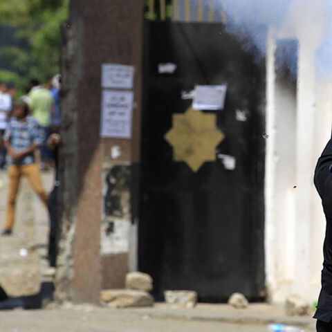 A riot police officer fires tear gas during clashes with student supporters of the Muslim Brotherhood and deposed President Mohamed Mursi at the Al-Azhar University campus in Cairo's Nasr City district, May 9, 2014. The protesters marched towards Rabaa square, closing the roads, during a demonstration by members of the Muslim Brotherhood and the pro-Mursi Anti-Coup National Alliance against the military, interior ministry and presidential candidate Abdel Fattah al-Sisi,, the former army chief who deposed th