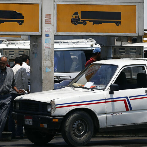 People wait to buy fuel at a petrol station in Cairo July 6, 2014. Egypt's Prime Minister Ibrahim Mehleb has sought to justify politically sensitive subsidy cuts on fuel and natural gas which took effect on Saturday, saying they were a necessary part of fixing an economy hammered by three years of turmoil. Egypt had overnight on Friday slashed its subsidies for car fuel and natural gas, increasing their prices by more than 70 percent. REUTERS/Amr Abdallah Dalsh  (EGYPT - Tags: POLITICS BUSINESS ENERGY TRANS