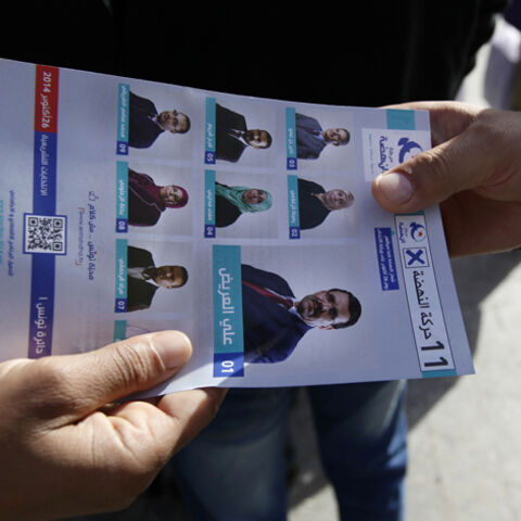 A supporter of the Ennahda Movement party distributes leaflets on the party's candidates for parliamentary elections, in Tunis October 22, 2014. Sunday's parliamentary vote will elect the 217-member assembly, and that will chose a new prime minister to lead the government to replace Tunisia's caretaker administration. Presidential elections will follow next month. REUTERS/Anis Mili (TUNISIA - Tags: POLITICS ELECTIONS) - RTR4B8QR