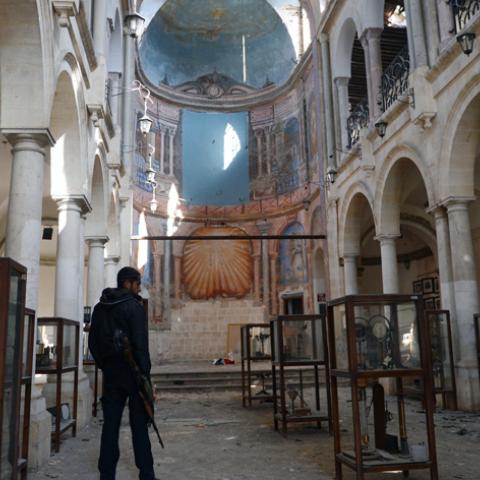 A Syrian rebel looks at damaged display cases inside a former church turned into a film museum which was shelleld by government forces in Aleppo's old city on January 17, 2013. Rebels trying to break a months-long deadlock in their battle for Syria's second city Aleppo say they are cutting supply routes ahead of simultaneous assaults on regime bases.  AFP PHOTO/AAMIR QURESHI        (Photo credit should read AAMIR QURESHI/AFP/Getty Images)