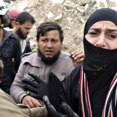 A woman reacts while civil defence members carry her dead child after what activists said was shelling by warplanes loyal to Syria's president Bashar Al-Assad in Aleppo's rebel-controlled Bab Al-Nairab district April 12, 2015. REUTERS/Abdalrhman Ismail  - RTR4X059